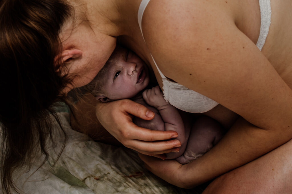 Niagara birth and postpartum doula holding her newborn baby right after birth