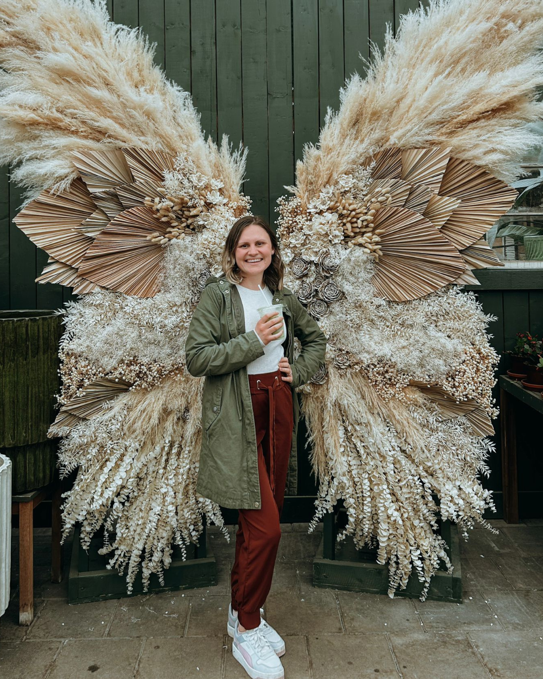 me holding a cup of coffee with angel wings