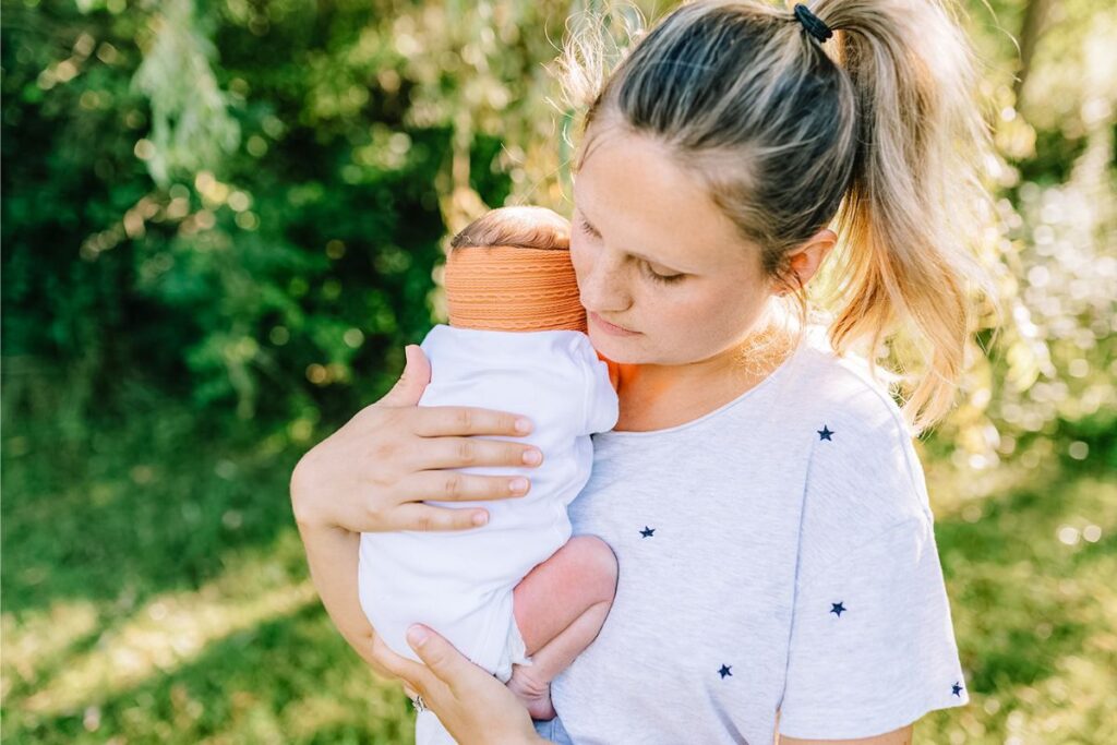 postpartum and doula mom holding newborn baby