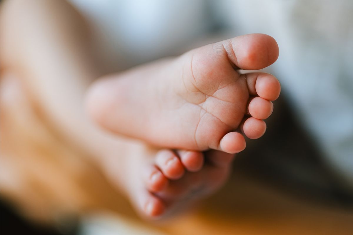 newborn baby's feet of a postpartum mother